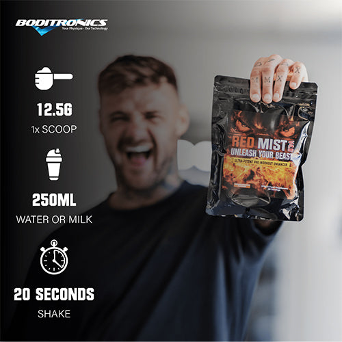 Boditronics Ambassador Ryan holding up Red Mist 375g orange and passionfruit pouch with mixing instructions mix 12.5g 1 scoop with 250ml water or milk then shake for 20 seconds