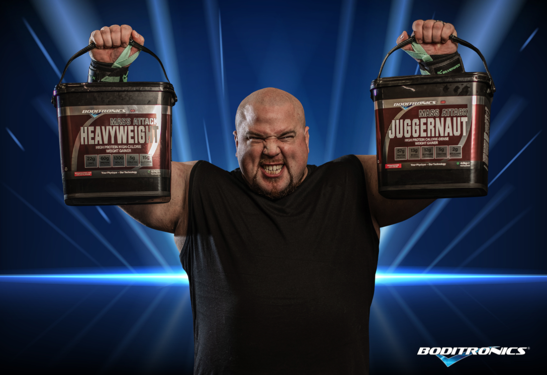 Ambassador Steve holding Heavyweight and Juggernaut against a blue background 